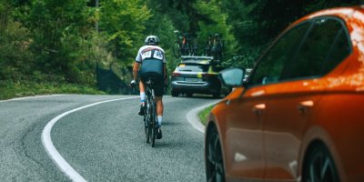 Silnice, na které jedou auta a cyklista