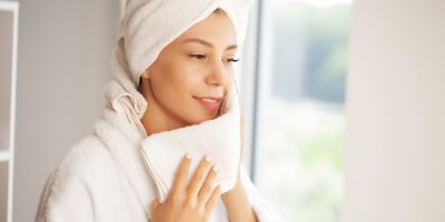 Žena si utírá obličej ručníkem