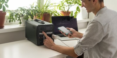 Muž nabíjí mobilní telefon přes powerbanku