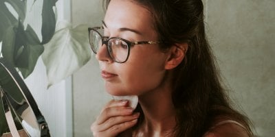 Žena masíruje bradu pomocí Gua Sha