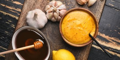 Hořčice, med, česnek a citron na prkénku