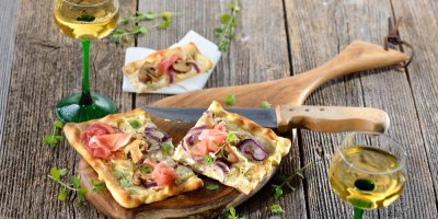 Alsaský cibulový koláč se sklenicemi bílého vína