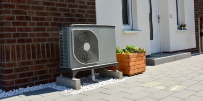 Vzduchové tepelné čerpadlo pro vytápění a teplou vodu před nově postavenou obytnou budovou