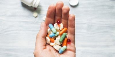 Ruka držící různé druhy léků