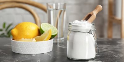 Jedlá soda ve sklenici, v pozadí mísa s citrusy