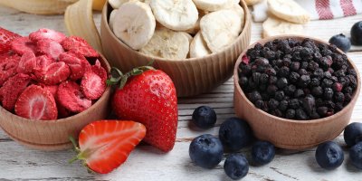 Dřevěné misky s lyofilizovanými jahodami, banány a barůvkami