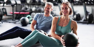 Muž a žena posilují ve fitness centru