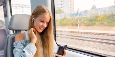 Dívka se sluchátky ve vlaku