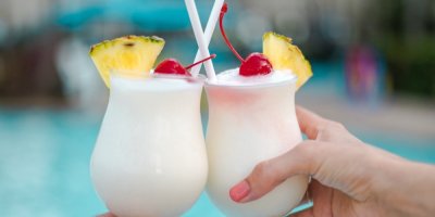 Dva lidé si přiťukávají koktejlem Piña Colada.