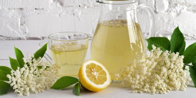 Sklenice s bezovou limonádou, citron a květy bezu