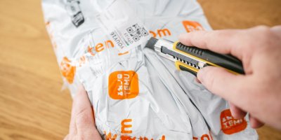 Muž otvírá balíček z TEMU