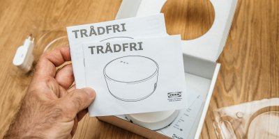 Muž drží manuál k osvětlení IKEA