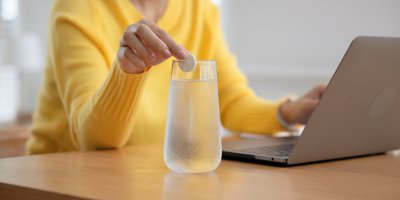 Žena ve žlutém svetru si připravuje šumivý nápoj