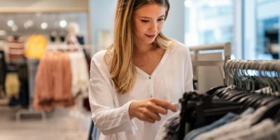 Mladá žena si vybírá oblečení v obchodě