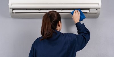 Člověk čistí klimatizaci hadříkem