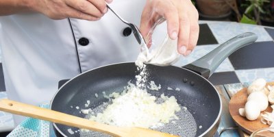 Kuchař sype mouku na pánev