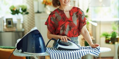 Žena žehlí parním generátorem tričko