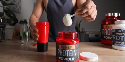 Muž připravuje proteinový nápoj z prášku