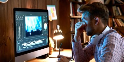 Muž sedí u obrazovky počítače a mne si unavené oči