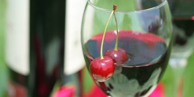 Třešeň ve skleničce s červenou tekutinou