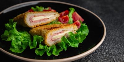 Masová kapsa plněná šunkou a sýrem, salát a rajčata