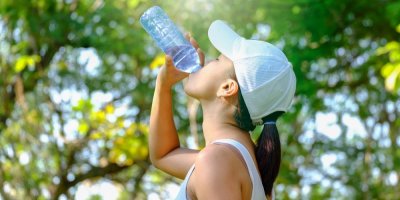 Žena pije z PET lahve vodu