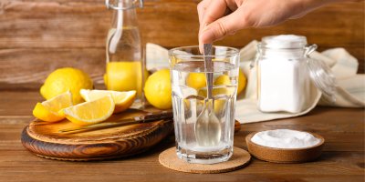 Míchání prášku ve vodě, v pozadí citrony a další