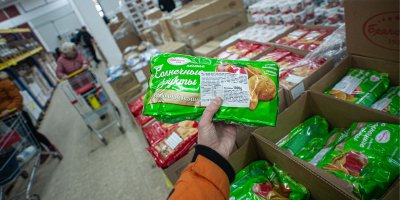 Ruka drží v obchodě produkt v zeleném obalu