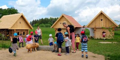 Děti u dřevěných chaloupek