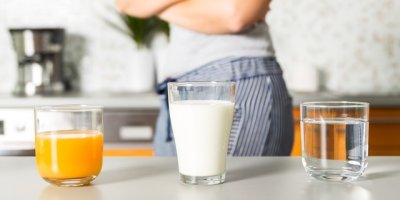 Tři sklenice na stole s mlékem, džusem a vodou