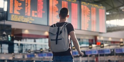 Mladý muž se dívá na informační tabuli na letišti