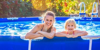 Mladá maminka s dcerou v nadzemním bazénu