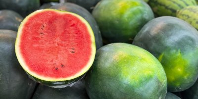 Rozkrojený melou na hromadě celých melounů