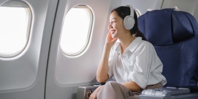Žena se sluchátky v letadle