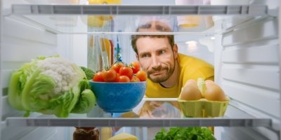 Muž se dívá dovnitř lednice