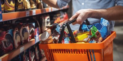 Muž drží v ruce plný nákupní košík