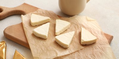 Trojúhelníčky  tavených sýrů na prkénku