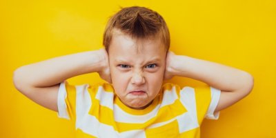 Malý kluk je naštvaný a zacpává si uši