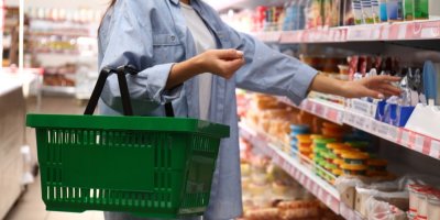 Žena s nákupním košíkem v ruce nakupuje