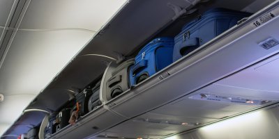 Kufry v zavazadlovém prostoru nad hlavami cestujících v letadle