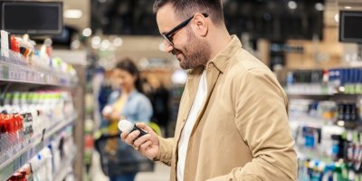 Muž v supermarketu drží kuličkový deodorant