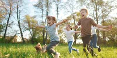 Děti běhají v přírodě se psem