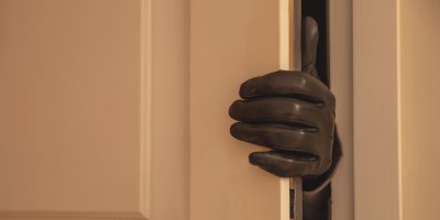 Ruka v černé rukavici se vloupává do domu