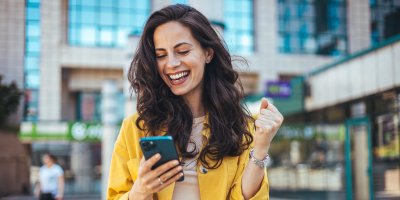 Šťastná žena s mobilem v ruce