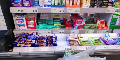 Sortiment zboží u poklady, sladké tyčinky a sušenky, léky a vitamíny