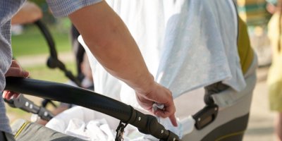 Muž dává plenku přes kočárek