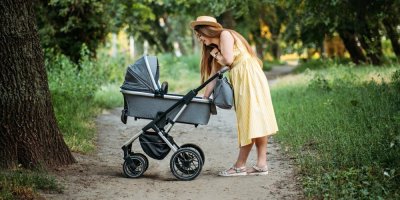 Žena s kočárkem v parku