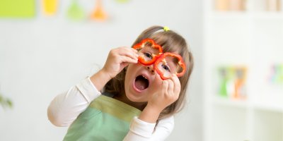 Holčička si hraje s plátky papriky