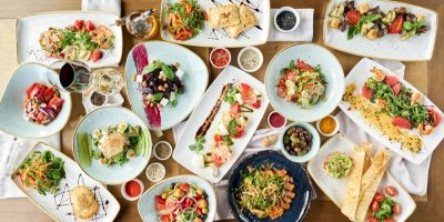 Stůl plný talířů s jídlem a omáčky