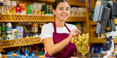 Mladá prodavačka u pokladny 